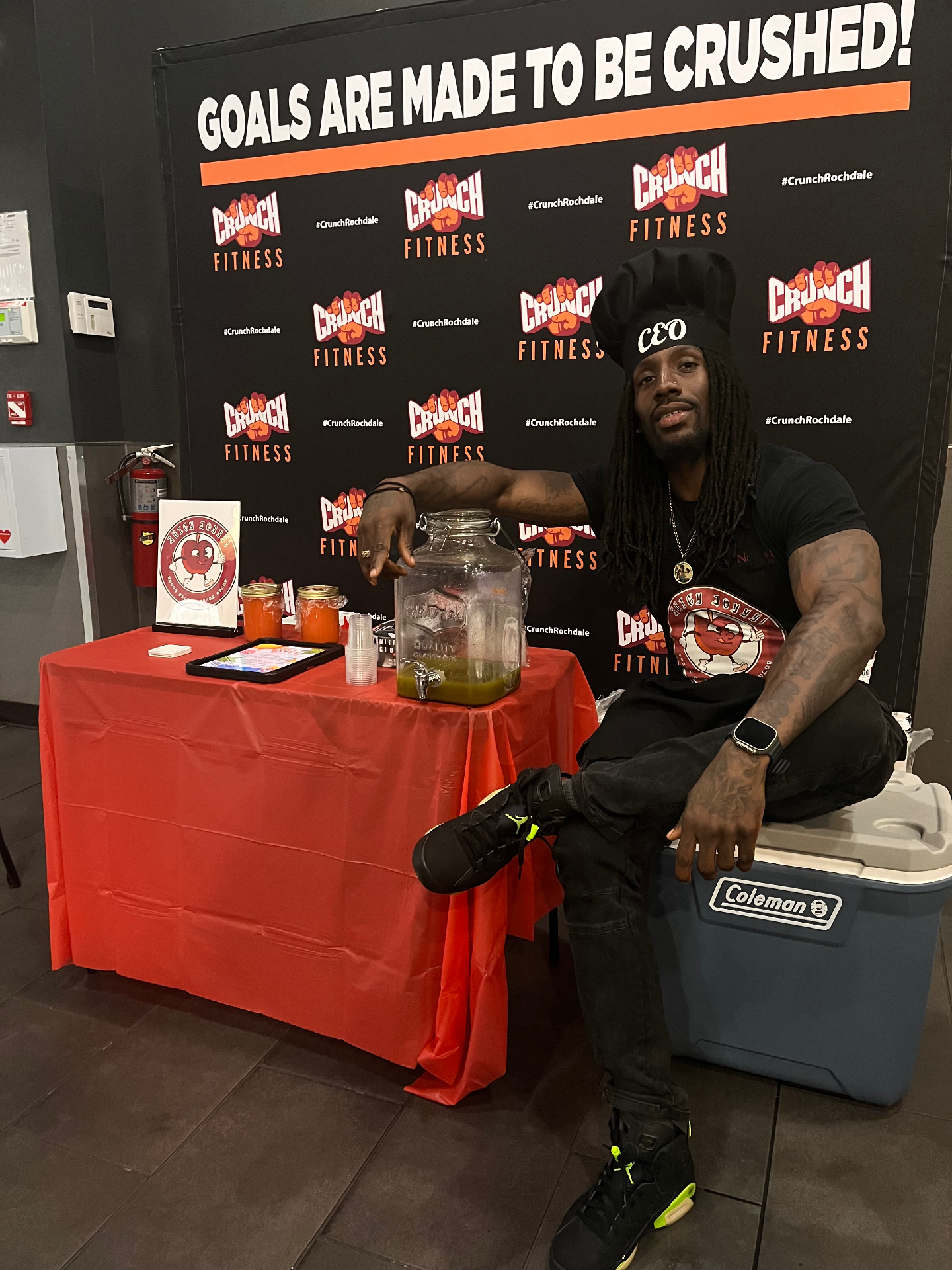 Joy, founder of Juicy Joyyy, pouring fresh green juice at a Crunch Fitness event